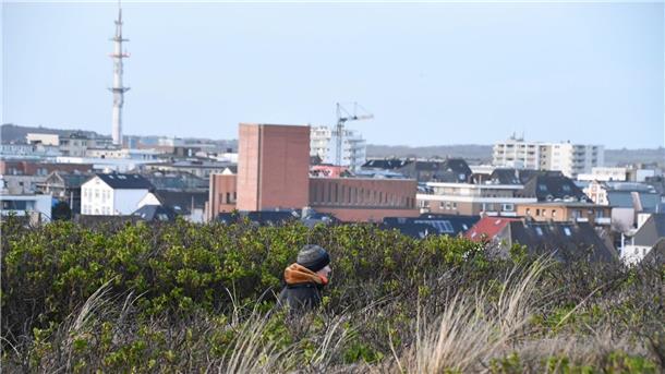 Ein Quadratmeter auf Sylt kostet im Schnitt über 14.400 Euro Ein Mann geht auf einem Weg über die Dünen.