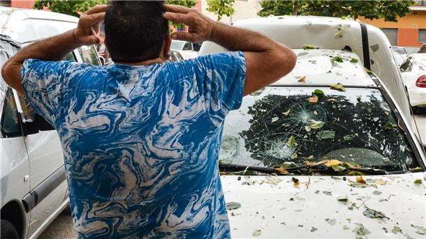 Ein Mann hält sich die Hände an den Kopf, nachdem er die Schäden an seinem Auto nach einem Hagelsturm gesehen hat. Am Dienstagabend fiel in La Bisbal d'Empordà, Katalonien, Hagel mit einem Durchmesser von bis zu 11 Zentimetern. Ein 20 Monate altes Mädchen starb an den Folgen der Verletzungen, die es sich bei dem Sturm zugezogen hatte. 