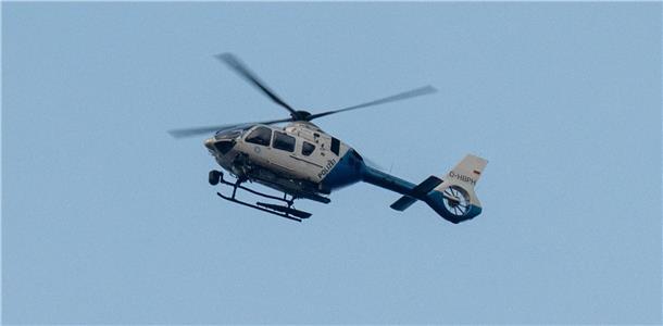 Ein Polizeihubschrauber fliegt über den Ortsrand von Parsberg, Bayern.