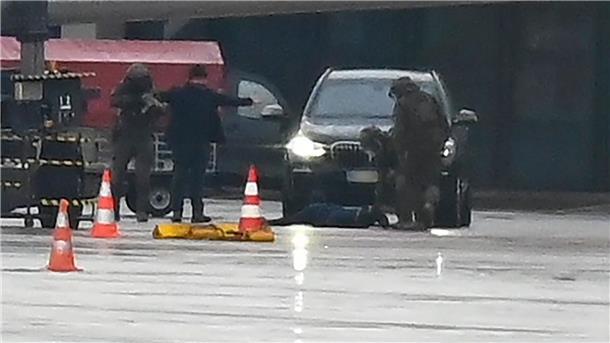 Hamburger Flughafen: Glückliches Ende einer Geiselnahme Ein Mann liegt am Hamburger Flughafen umringt von Polizeikräften auf dem Boden.