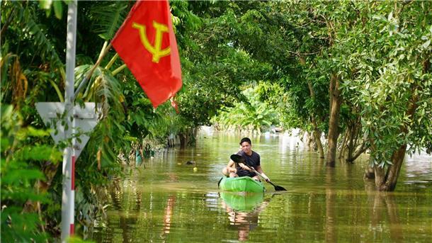 Ein Mann paddelt in der Nähe von Hanoi durch das Hochwasser.