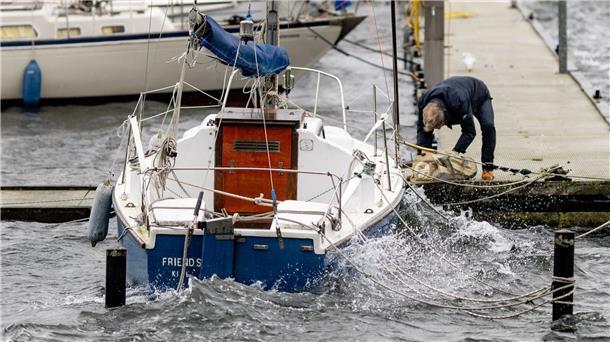 Norden bereitet sich auf schwere Ostsee-Sturmflut vor Ein Mann sichert ein Segelboot an einem Anlegesteg in der Kieler Förde.