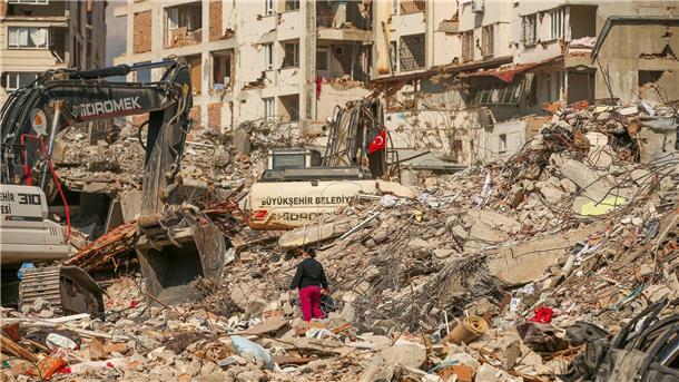 Dutzende Nachbeben binnen Stunden in der Türkei und Syrien Ein Mann steht in Samandag in der Türkei zwischen Trümmern, während Bagger die Überreste eines zerstörten Gebäudes abtransportieren. Nach dem katastrophalen Beben am 6.2. kommt es in der Region immer wieder zu Nachbeben.