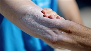 Ein Mann verreibt Sonnencreme auf seinem Arm. Einer aktuellen Umfrage zufolge nutzt gut ein Drittel aller Befragten im Frühjahr und Sommer normalerweise kein Sonnenschutzmittel.