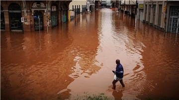 Ein Mann watet in Porto Alegre im brasilianischen Bundesstaat Rio Grande do Sul durch ein von schweren Regenfällen überschwemmtes Gebiet.