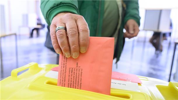 Ein Mann wirft seinen Wahlzettel für die Bundestagswahl 2025 in der Briefwahlstelle im Neuen Rathaus in eine Urne. 