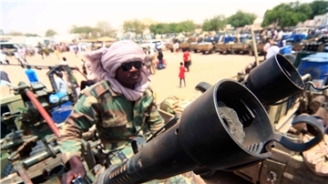 Ein Milizionär mit militärischer Ausrüstung, die angeblich während eines Gefechts im umkämpften Gebiet in Süd-Darfur erbeutet wurde (Archivbild).