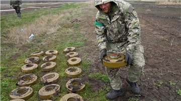 Ein Mitarbeiter des ukrainischen Innenministeriums sammelt Mienen in Irpin (Archiv).