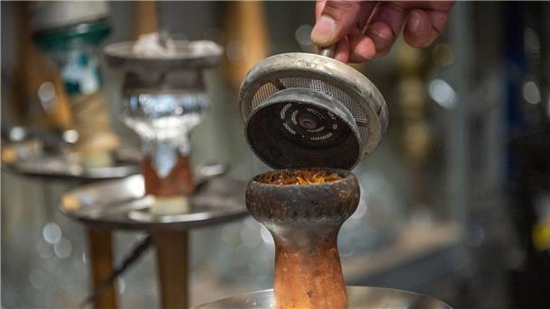 Geschäft mit Shisha-Tabak bricht ein - Schwarzmarkt-Boom? Ein Mitarbeiter füllt in einer Shisha-Bar Tabak in den Kopf der Pfeife.