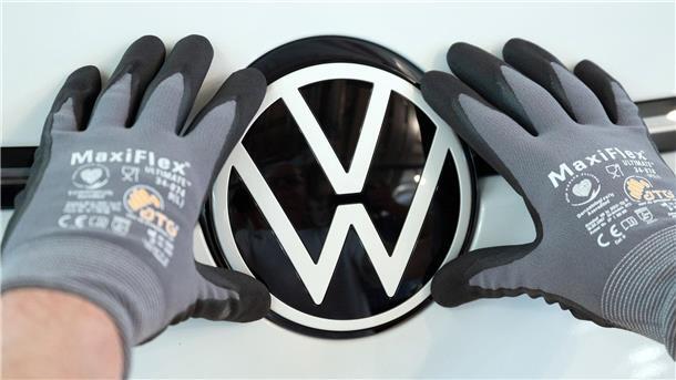 Nächstes VW-Batteriezellwerk: Produktion in Spanien ab 2026 Ein Mitarbeiter von Volkswagen setzt das VW-Logo in die Front eines VW ID.3 ein.