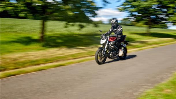 Ein Motorradfahrer fährt mit einem 125ccm-Bike über eine Landstraße.