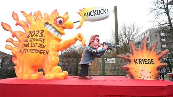 Rosenmontagszüge in Köln, Düsseldorf und Mainz unterwegs Ein Mottowagen in Düsseldorf erinnert an den Klimawandel.
