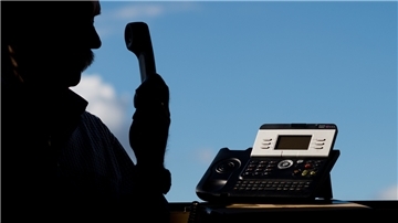 ILLUSTRATION: Ein Mann hält einen Telefonhörer in der Hand. 