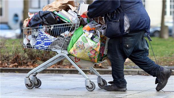 Armutskonferenz fordert Aktionsplan gegen Wohnungslosigkeit Ein obdachloser Mann schiebt einen Einkaufswagen über eine Fußgängerstraße in Berlin.