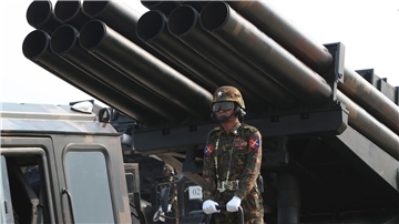 Ein Offizier steht während einer Militärparade auf einem mit Raketen beladenen Lastwagen.