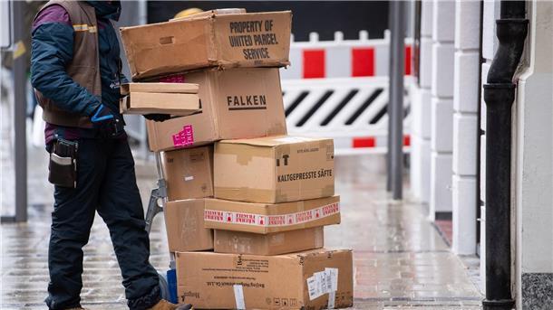 Ein Paketbote liefert Pakete aus.