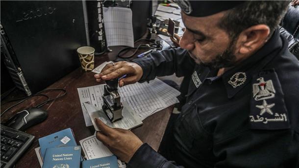 Geschäft mit Menschen: Gaza-Ausreise für 10.000 Dollar Ein palästinensischer Beamter kontrolliert die Pässe: Können die Menschen den Gazastreifen in Richtung Ägypten verlassen?
