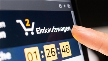 Ein Person klickt beim Online-Shoppen auf den Einkaufswagen.