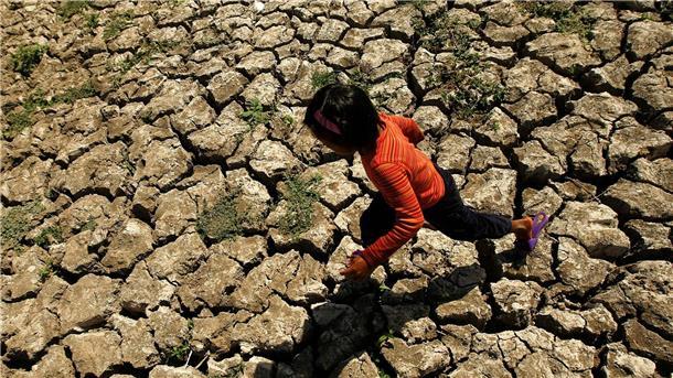 Ein philippinisches Kind läuft in der Provinz Cavite auf den Philippinen in einem ausgetrockneten Bewässerungskanal, der durch das Wetterphänomen „El Niño“ ausgetrocknet war.