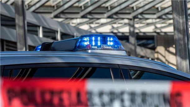 Ein Polizei-Blaulicht leuchtet über einem Absperrband mit der Aufschrift „Polizeiabsperrung“.