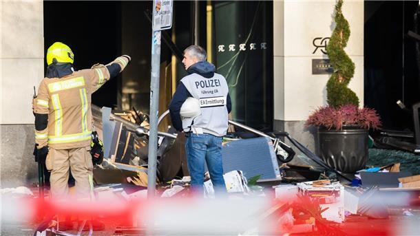 Geplatztes Aquarium: Etwa 630 Fische gerettet Ein Polizeibeamter begutachtet neben einem Feuerwehrmann die Trümmer vor dem Hotel auf der Karl-Liebknecht-Straße.