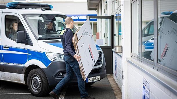 AfD weist Vorwurf gegen Landtagsabgeordneten zurück Ein Polizeibeamter geht während einer Durchsuchung an einem Polizeiwagen vorbei.