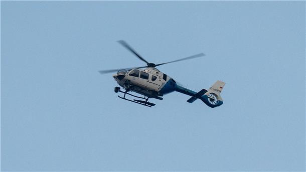 Zwei Tote bei zwei Feiern in Bayern - Täter weiter flüchtig Ein Polizeihubschrauber fliegt über den Ortsrand in Parsberg.