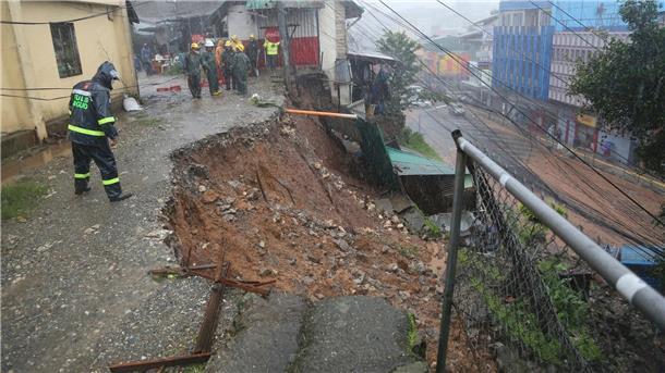 Ein Polizist inspiziert einen durch den Taifun „Doksuri“ verursachten Erdrutsch in einem Wohngebiet in Baguio City.