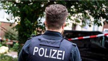 Ein Polizist steht am Ort eines Polizeieinsatzes.