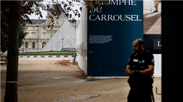 Ein Polizist steht vor dem Louvre Wache, der wegen einer Bombendrohung geräumt worden war.