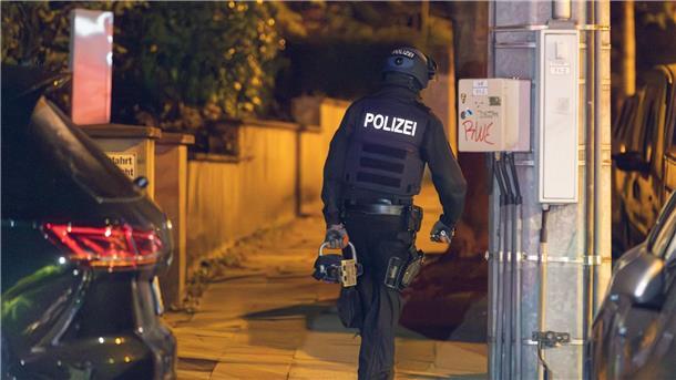 Ein Polizist trägt während der Razzia in Essen einen hydraulischen Türöffner.
