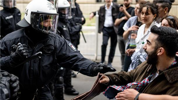Ein Polizist und ein Demonstrant stoßen bei der Demonstration in Berlin-Mitte aufeinander. Die Polizei war mit rund 900 Kräften in der Stadt im Einsatz.