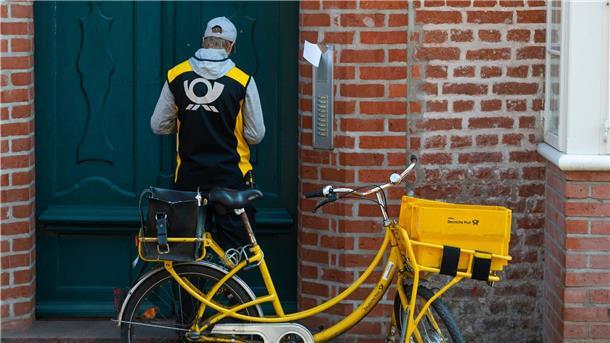 Hund beißt Postboten in Hintern Ein Postbote verteilt Briefe.