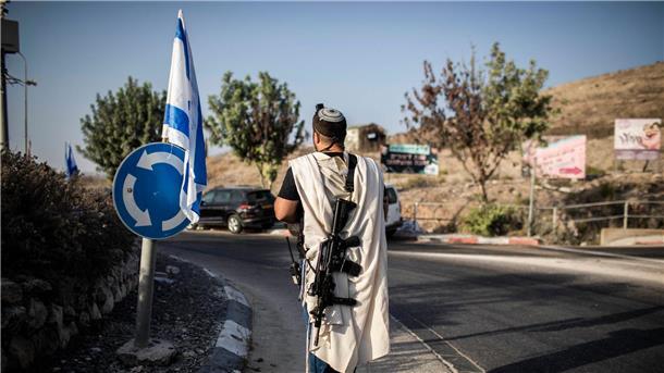 EU verhängt erstmals Sanktionen gegen israelische Siedler Ein rechtsgerichteter israelischer Siedler trägt eine Waffe nahe der palästinensischen Stadt Nablus im Westjordanland (Archivfoto). Die EU verhängt erstmals Sanktionen wegen der Gewalt radikaler israelischer Siedler.