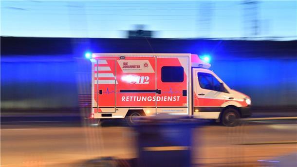 Mann schwebt nach Sturz aus Fenster in Lebensgefahr Ein Rettungswagen ist mit eingeschaltetem Blaulicht im Einsatz.