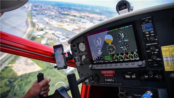 Ein Pilot steuert einen Motorsegler. 