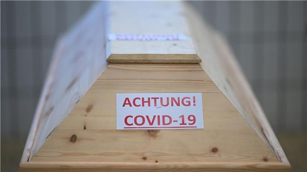 WHO: Pandemie vernichtete mehr als 300 Millionen Lebensjahre Ein Sarg mit der Aufschrift „Achtung! Covid-19“ in einem Raum im Krematorium, bevor der Sarg eingeäschert wird.