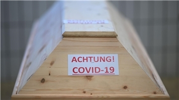 Ein Sarg mit der Aufschrift „Achtung! Covid-19“ in einem Raum im Krematorium, bevor der Sarg eingeäschert wird.