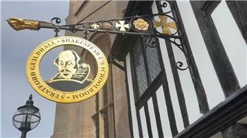 Ein Schild an einem historischen Gebäude (Guildhall) in der englischen Stadt Stratford-upon-Avon erinnert an den Schriftsteller William Shakespeare.