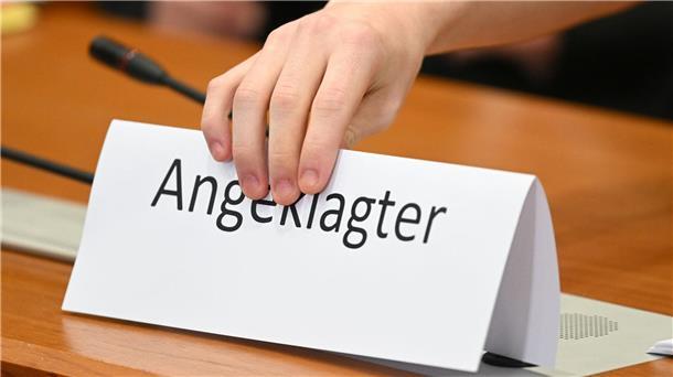 Diebstahl im Juweliergeschäft - Prozessbeginn verzögert sich Ein Schild mit der Aufschrift „Angeklagter“ wird auf die Gerichtsbank gestellt.
