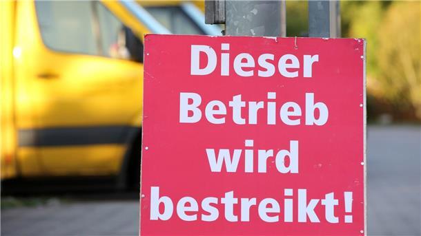 Verdi ruft Post-Beschäftigte zu Warnstreiks auf Ein Schild mit der Aufschrift „Dieser Betrieb wird bestreikt“ steht vor einer bestreikten Deutsche-Post-DHL-Niederlassung.