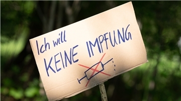 Ein Schild mit der Aufschrift „Ich will keine Impfung“ ist am Rande einer Kundgebung zu sehen.