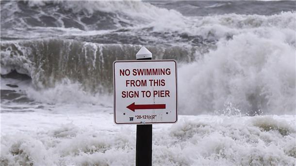Hurrikan „Nicole“ schwächt sich ab Ein Schild mit der Aufschrift „Schwimmen verboten“ steht vor den Wellen in Daytona Beach. Der Sturm „Nicole“ steuert auf die Ostküste der USA zu.