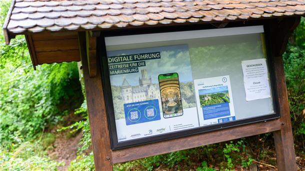 Virtueller Rundgang soll Schloss Marienburg erlebbar machen Ein Schild weist auf eine digitale Führung per Smartphone am Schloss Marienburg in der Region Hannover hin.