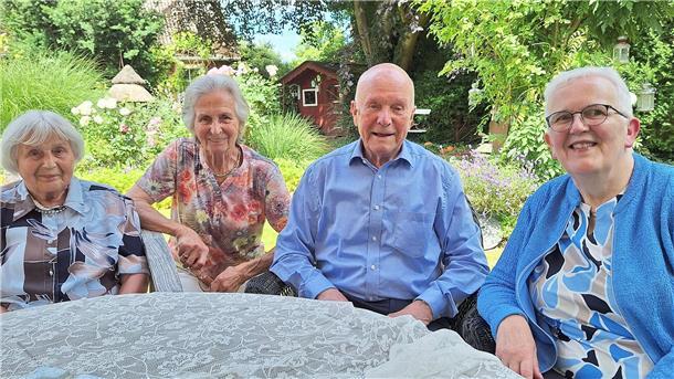 Drei Frauen und ein Mann sitzen an einem Tisch.