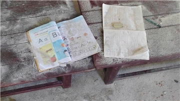 Ein Schulbuch und ein Notizheft liegen staubbedeckt in den Überresten der angegriffenen Schule in der Region Sagaing.