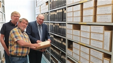 Ein sechs Meter breites und 2,70 Meter hohes Regal ist nun in 34 Fächern mit Unterlagen der Alt-Gemeinde Rodenkirchen gefüllt. Manfred Kirsch und Eckhard Meyer (von links) zeigten Bürgermeister Harald Stindt diesen Schatz.