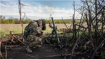 Ein Soldat einer Mörser-Einheit der ukrainischen Streitkräfte hält sich die Ohren zu, während er auf feindliche Stellungen in den Vororten der Stadt Bachmut feuert.