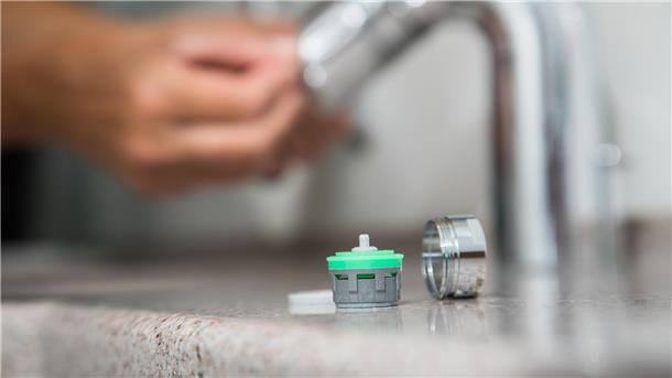 Ein Strahlregler, der vor den Wasserhahn geschraubt wird, hilft, Wasser zu sparen.