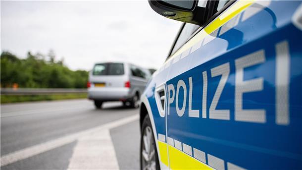 Ein Streifenwagen der Polizei steht auf einer Straße.